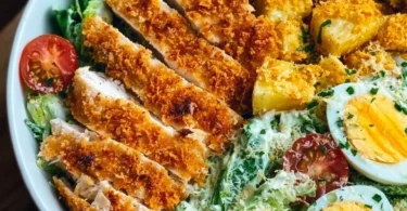 Leckere Caesar-Hähnchen-Bowl mit frischen Zutaten und Dressing.