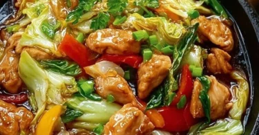 Chinesische Hähnchenpfanne mit Spitzkohl und Zwiebel auf einem Teller angerichtet