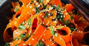 Karottensalat mit Ingwer-Sesam-Dressing auf einem Teller serviert